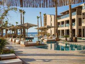 a resort with a swimming pool and palm trees at Nalu Resort & SPA Adults Only Hotel in Adelianos Kampos