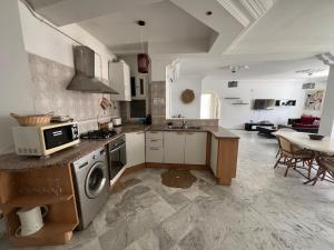 una cocina con fregadero y estufa horno superior en Cozy apartment Chatt Meriem, en Chott Meriem