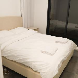 a white bed with two white towels on it at Alma suite in Ashdot Ya‘aqov +8 photos