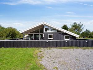 una casa con una valla negra en Holiday Home Blondine - 940m from the sea by Interhome, en Hjørring