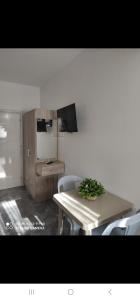 a dining room with a table and a refrigerator at Villa Baka Studio Apartments in Sarandë