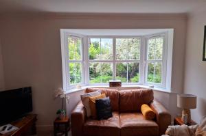 イルクリーにあるStylish home close to the Yorkshire Dales & Leeds Airportの大きな窓のあるリビングルーム(ソファ付)