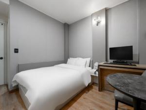 a bedroom with a large white bed and a television at 3S HOTEL ANYANG 1st FASHION in Anyang +6 photos