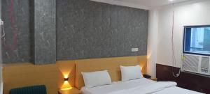 JāmbにあるHotel Monarch Innのベッドが2つあり、壁に絵が飾られた寝室