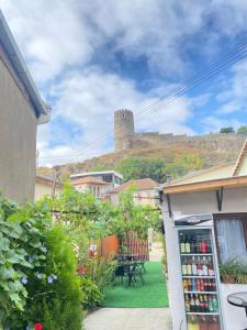 a soda machine in a yard with a castle in the background at Imperia in Akhaltsikhe