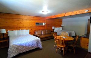 a hotel room with a bed and a couch and a table at Packwood Inn in Packwood