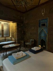 sala de estar con 2 camas y chimenea en Villa Tabori, en Tiflis