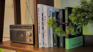 ein Regal mit einem Stapel Bücher und einem Fernseher in der Unterkunft 해방스테이 #3룸 in Seoul