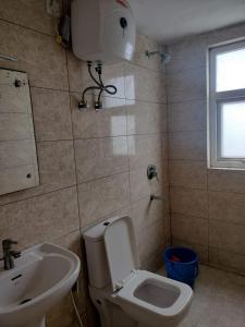 un baño con inodoro y lavabo en Eternity Grand Vrindavan, en Chhatikara 26 fotos más