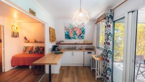 a kitchen with a desk and a sink in a room at Appart. VANILLE T3 en RDJ proche du lagon in Saint-Gilles les Bains