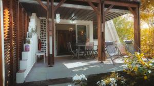 a screened in porch with a table and chairs at Appart. VANILLE T3 en RDJ proche du lagon in Saint-Gilles les Bains