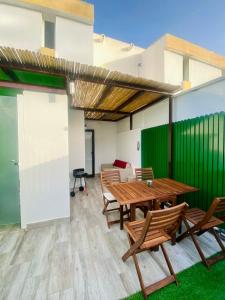 a patio with a wooden table and chairs at Vega Maspalomas in San Bartolomé de Tirajana