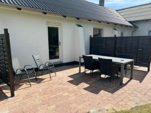 a patio with a table and chairs in front of a house at Ammitsbøl Apartment D in Vejle