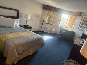 a hotel room with a bed and a desk at Apm Inn & Suites in Hagerstown