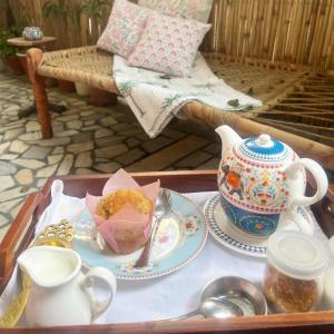 a tray with a tea set on a table with a tea pot at Mizpah Delhi in New Delhi