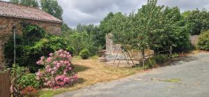 a garden with pink flowers next to a building at Chambre les orchidées in Montournais