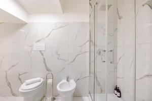 ein weißes Badezimmer mit Toilette und Dusche in der Unterkunft Kiros - appartement 6 personnes - check in h24 - wifi in Lyon
