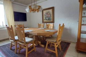 a dining room with a wooden table and chairs at Haus Bremon - Monteur- und Ferienunterkunft Raum Aachen in ruhiger Lage in Alsdorf