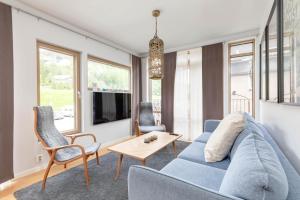 a living room with a blue couch and chairs at Åre Travel - Mörviksgården in Åre