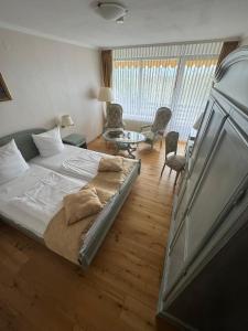 a bedroom with a bed and a table and chairs at Parkhotel Maasberg in Bad Sobernheim