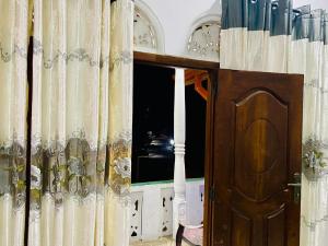 a room with a door and a window with curtains at VD Rest Gampola in Gampola