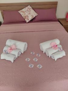 Una cama con toallas blancas y flores rosas. en Casa di Lety Holiday House, en Civitavecchia 20 fotos más