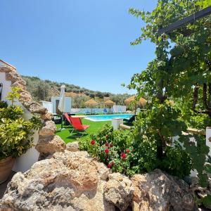 a garden with rocks and a swimming pool at Casa rural Antonio y Esperanza in Periana