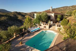 una vista aérea de una piscina con sillas y una casa en Villa 16 by Villamya, en Zahara de la Sierra
