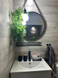 um banheiro com pia branca e espelho em Къща за гости Рилски чардак em Sapareva Banya