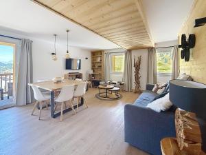 a living room with a blue couch and a table at Le Chaberton - Les Tanières de Montgenèvre - Appartement 6 à 8 personnes front de neige in Montgenèvre