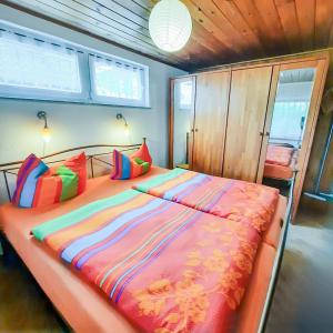 a bedroom with a large bed with colorful pillows at Bungalow 1 in Quetzin