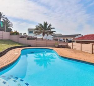 a large swimming pool with blue water in a yard at Natspat 10 in Margate