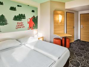 ein Schlafzimmer mit einem weißen Bett und einem Schreibtisch in der Unterkunft B&B Hotel Aschaffenburg in Aschaffenburg + 20 Fotos