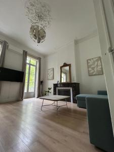 a living room with a couch and a table at Appartement Avenue Feuchères Arènes in Nîmes