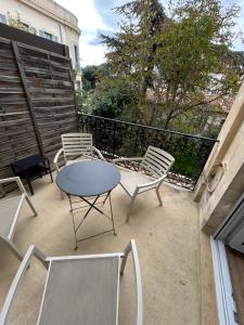 a patio with a table and chairs on a balcony at Appartement Avenue Feuchères Arènes in Nîmes