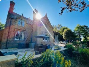 a brick house with the sun shining on it at Lodge - Sleeps 18 pet friendly & free parking in Ravensworth