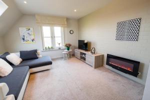 a living room with a couch and a fireplace at SHAMBALLA logies nieuw en zeer verzorgd appartement met voortuin en terras in Deinze