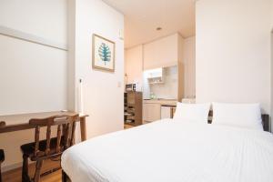a bedroom with a white bed and a desk at Wen's House in Tokyo