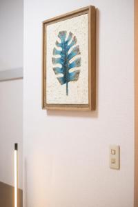 a picture of a blue leaf on a wall at Wen's House in Tokyo