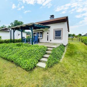 a small white house with a porch and stairs at Bungalow 2 in Quetzin