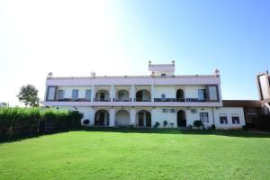 una gran casa blanca con un gran patio en Ranthambore Sawai Palace, en Sawāi Mādhopur
