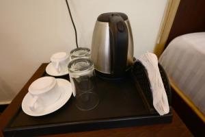 una cafetera y tazas en una bandeja sobre una mesa en Ranthambore Sawai Palace, en Sawāi Mādhopur
