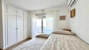 two beds in a bedroom with a window at Magnífico Ático 4 hab frente a la playa con piscinas parking incluido por keywise in Fuengirola +37 photos