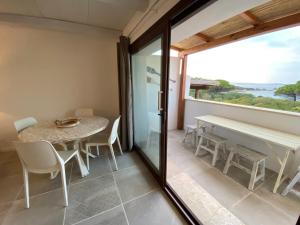 een eetkamer met een tafel en stoelen en een raam bij Rena Bianca Residence 225 in Baja Sardinia