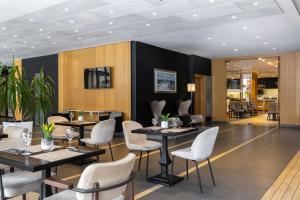 a restaurant with tables and chairs in a room at Nobel Palace Hotel in Belgrade