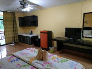 a room with a bed and a desk and a television at Rattana's Resort in Ranong