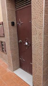 a brown door with a flower on a wall at apartement in tamraght in Agadir +12 photos