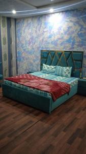 Bett in einem Zimmer mit einer farbenfrohen Wand in der Unterkunft safari hotel shimlapahari in Lahore