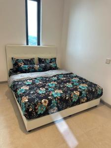a bed with a floral comforter in a bedroom at 22 Macalisterz 2025 Georgetown Premium 顶楼无边泳池 in George Town