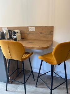 a desk with two yellow chairs at a table at La Source Bleue in Le Chalon +8 photos